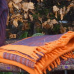 Die "Orange Harmony Bliss" Kaschmilon-Decke, 130 x 2,30 Meter groß, vereint lebendiges Orange mit einem verspielten Melange-Rand in Dunkelgrau, Rot und Blaugrau. Dick gewebt und leicht, bietet sie luxuriösen Komfort und Wärme. Tauche ein in die Magie von "Orange Harmony Bliss" und erlebe Gemütlichkeit in einem farbenfrohen Gewand.