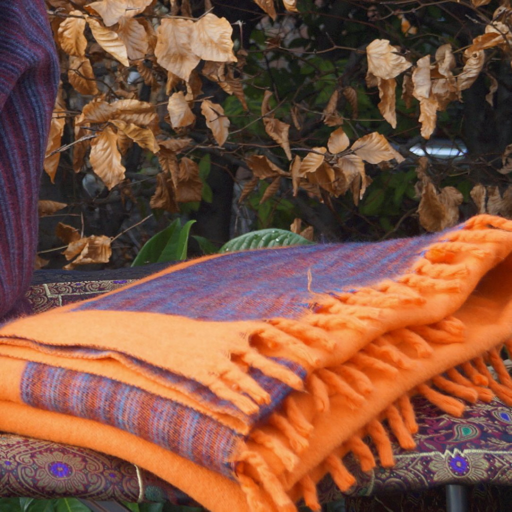 ID_SSB_1351_2_d Die "Orange Harmony Bliss" Kaschmilon-Decke, 130 x 2,30 Meter groß, vereint lebendiges Orange mit einem verspielten Melange-Rand in Dunkelgrau, Rot und Blaugrau. Dick gewebt und leicht, bietet sie luxuriösen Komfort und Wärme. Tauche ein in die Magie von "Orange Harmony Bliss" und erlebe Gemütlichkeit in einem farbenfrohen Gewand.