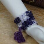 In der Bergstille, tief meditierend, vereine ich mich mit der Natur. Fühlingsgrün umhüllt mich, die Cosmic Clarity Mala in meiner Linken. Die Sonne streichelt, die Luft ist rein. Die Mala – Amethyst, Bergkristall, Silber – warm und kühl zugleich. Ein magisches Tanzspiel von Licht und Dunkelheit, Tiefe und Klarheit. Inmitten der Bergspitzen entfaltet die Mala geheimnisvolle Geschichten des Kosmos. Ein stiller Zeuge der Bergweisheit, getränkt von Sonnenwärme und Bergklarheit