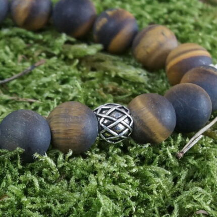"Zen-Zauber" – Das Tigerauge Yogaarmband vereint inneren Frieden und Balance durch kraftvolle Eigenschaften. Die Silberperle mit Wikingerspiralen stärkt den Geist während der Meditation und fördert Selbstvertrauen. Perfekt für das Solarplexus-Chakra, schafft dieses Armband eine energetische Brücke zwischen Tigerauge und Silber für spirituelle Reisen und innere Harmonie.