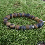 "Zen-Zauber" – Das Tigerauge Yogaarmband vereint inneren Frieden und Balance durch kraftvolle Eigenschaften. Die Silberperle mit Wikingerspiralen stärkt den Geist während der Meditation und fördert Selbstvertrauen. Perfekt für das Solarplexus-Chakra, schafft dieses Armband eine energetische Brücke zwischen Tigerauge und Silber für spirituelle Reisen und innere Harmonie.