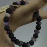 "Lavendelträume" ist ein königliches Armband aus Amethyst Rondelle (10mm) und lebendigen Lava Perlen (10mm), das spirituelle Harmonie fördert. Durch die einzigartige Synergie der beiden Steine öffnet es das Kronen-Chakra und unterstützt die innere Balance. Regelmäßige Reinigung unter fließendem Wasser und Aufladen im Mondlicht bewahren die kraftvolle Energie dieses besonderen Schmuckstücks.