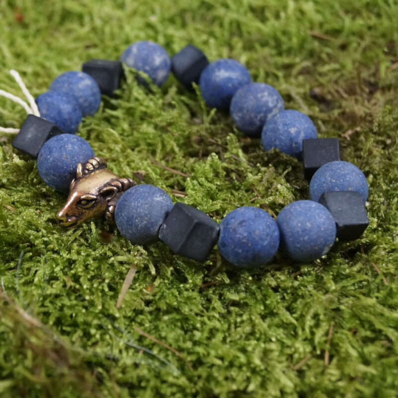 Aetheria Vigor - Einzigartiges Perlenarmband mit Dumerorierit, Onyx, Bergkristall und bronzenem Widderkopf: Dieses kraftvolle Schmuckstück vereint Dumerorierit für Erdung, Onyx für Selbstbeherrschung, Bergkristall für mentale Klarheit und einen bronzenen Widderkopf als Symbol des inneren Kriegergeistes. Spirituelle Verbindung durch die Zeiten: Die Wikingerzeit inspiriert den Widderkopf, während die Steine, in Harmonie kombiniert, Sternzeichen wie Widder, Stier und Steinbock stärken und spirituelle Erkenntnisse fördern. Faszination in Eleganz: Trage "Aetheria Vigor" mit Freude als nicht nur ästhetisches Accessoire, sondern als Begleiter auf deiner spirituellen Reise, der die Kräfte von Erde, Selbstbeherrschung, Klarheit und Kriegergeist vereint.