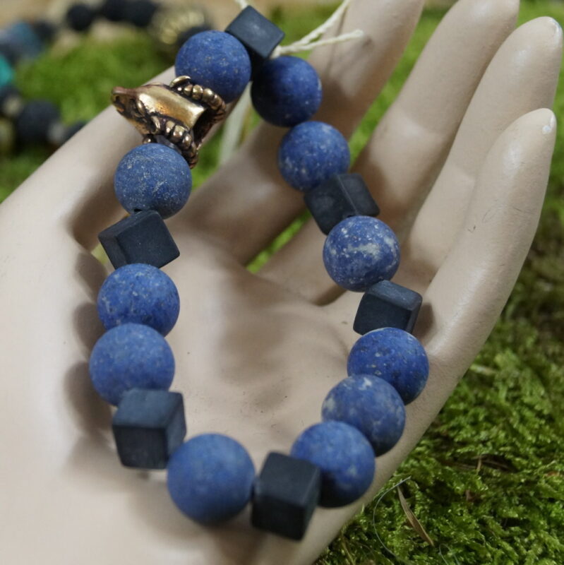 Aetheria Vigor - Einzigartiges Perlenarmband mit Dumerorierit, Onyx, Bergkristall und bronzenem Widderkopf: Dieses kraftvolle Schmuckstück vereint Dumerorierit für Erdung, Onyx für Selbstbeherrschung, Bergkristall für mentale Klarheit und einen bronzenen Widderkopf als Symbol des inneren Kriegergeistes. Spirituelle Verbindung durch die Zeiten: Die Wikingerzeit inspiriert den Widderkopf, während die Steine, in Harmonie kombiniert, Sternzeichen wie Widder, Stier und Steinbock stärken und spirituelle Erkenntnisse fördern. Faszination in Eleganz: Trage "Aetheria Vigor" mit Freude als nicht nur ästhetisches Accessoire, sondern als Begleiter auf deiner spirituellen Reise, der die Kräfte von Erde, Selbstbeherrschung, Klarheit und Kriegergeist vereint.