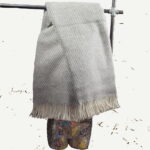 Tauchen Sie ein in die frostige Eleganz von Grönland mit unserer exquisiten Grönlandwolldecke. Diese meisterhaft gewebte Decke, mit einem eleganten Streifenmuster in den Farben von Schnee und Himmel, verkörpert die robuste Schönheit der arktischen Landschaft. Mit großzügigen 135 mal 240 cm ist diese Decke nicht nur luxuriös lang, sondern auch mit einem Gewicht von 1,176 Gramm unglaublich wertig. Jeder Streifen erzählt von den endlosen Schneefeldern und den majestätischen Gletschern Grönlands.