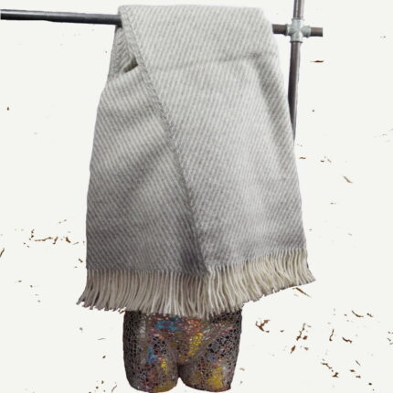 Tauchen Sie ein in die frostige Eleganz von Grönland mit unserer exquisiten Grönlandwolldecke. Diese meisterhaft gewebte Decke, mit einem eleganten Streifenmuster in den Farben von Schnee und Himmel, verkörpert die robuste Schönheit der arktischen Landschaft. Mit großzügigen 135 mal 240 cm ist diese Decke nicht nur luxuriös lang, sondern auch mit einem Gewicht von 1,176 Gramm unglaublich wertig. Jeder Streifen erzählt von den endlosen Schneefeldern und den majestätischen Gletschern Grönlands.