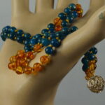 Erlebe mit der "EastSea Fusion Mala" die Fusion von Bernstein, Malachit und Silber in einer magischen Verbindung. Wie sanfte Wellen nach einem Sturm, vereinen sich die Steine zu einer harmonischen Mala. Die Quaste symbolisiert Vollständigkeit und verstärkt die heilenden und spirituellen Eigenschaften. Spüre die kühle Meeresbrise und lass dich von dieser einzigartigen Mala verzaubern!