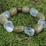 "Savana-Magie" - Ein Abenteuer in Form eines Armbands mit warmen Afrikaopalen und erfrischendem Bergkristall. Die 11mm große Bronceperle mit Wikingerspiralen verbindet Vergangenheit und Gegenwart in einem kraftvollen Trio, das spirituelle Reisen und Lebensfreude fördert. Vorteilhaft für das Herz-Chakra, symbolisiert die Bronceperle mit ihrer warmen Patina Stärke und Beständigkeit, während regelmäßige Reinigung die lebendige Energie bewahrt.