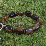 Tigerauge, auch als "Cat's Eye" bekannt, findet im irischen Glauben eine besondere Verbindung. Der Stein wird mit Schutz und Wohlstand assoziiert und symbolisiert die stärkende Energie des Tigers. In der irischen Kultur wird Tigerauge oft als Glücksstein betrachtet, der vor negativen Energien schützt und den Träger in schwierigen Zeiten stärkt. Spirituell wird Tigerauge als Verbindung zur Natur und den mystischen Kräften der irischen Landschaft gesehen. In keltischer Sichtweise symbolisiert der Stein auch Mut und Entschlossenheit. Yoga-Praktizierende können durch Tigerauge eine Erdung und Stabilität in ihrer Praxis erfahren. Schamanisch betrachtet wird Tigerauge als ein Stein der Visionen und inneren Reisen angesehen. In Verbindung mit dem irischen Glauben entfaltet Tigerauge eine kraftvolle, schützende Aura und wird mit Sternzeichen wie Stier und Löwe in Einklang gebracht. Die Reinigung kann durch Erdung in der Natur oder durch Räuchern erfolgen, um seine energetischen Qualitäten zu bewahren.