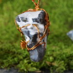 "CaelumGuardian" verbindet keltische Mystik mit der natürlichen Energie der Ostsee. Dieses einzigartige Amulett, kunstvoll verziert mit Kupfer und Kupferspiralen, trägt einen beeindruckenden Hünergott-Stein. Die runde, graue Oberfläche mit weißen Einschlüssen verleiht mystische Ausstrahlung. Der Hünergott, mit natürlichen Löchern, wird als Glücksbringer angesehen und repräsentiert Schutz in keltischer Kultur. Ein Symbol für spirituelle Verbindung, begleitet "CaelumGuardian" auf deiner Reise als himmlischer Wächter. Tauche ein in diese einzigartige Kombination von Natur und Kunst.